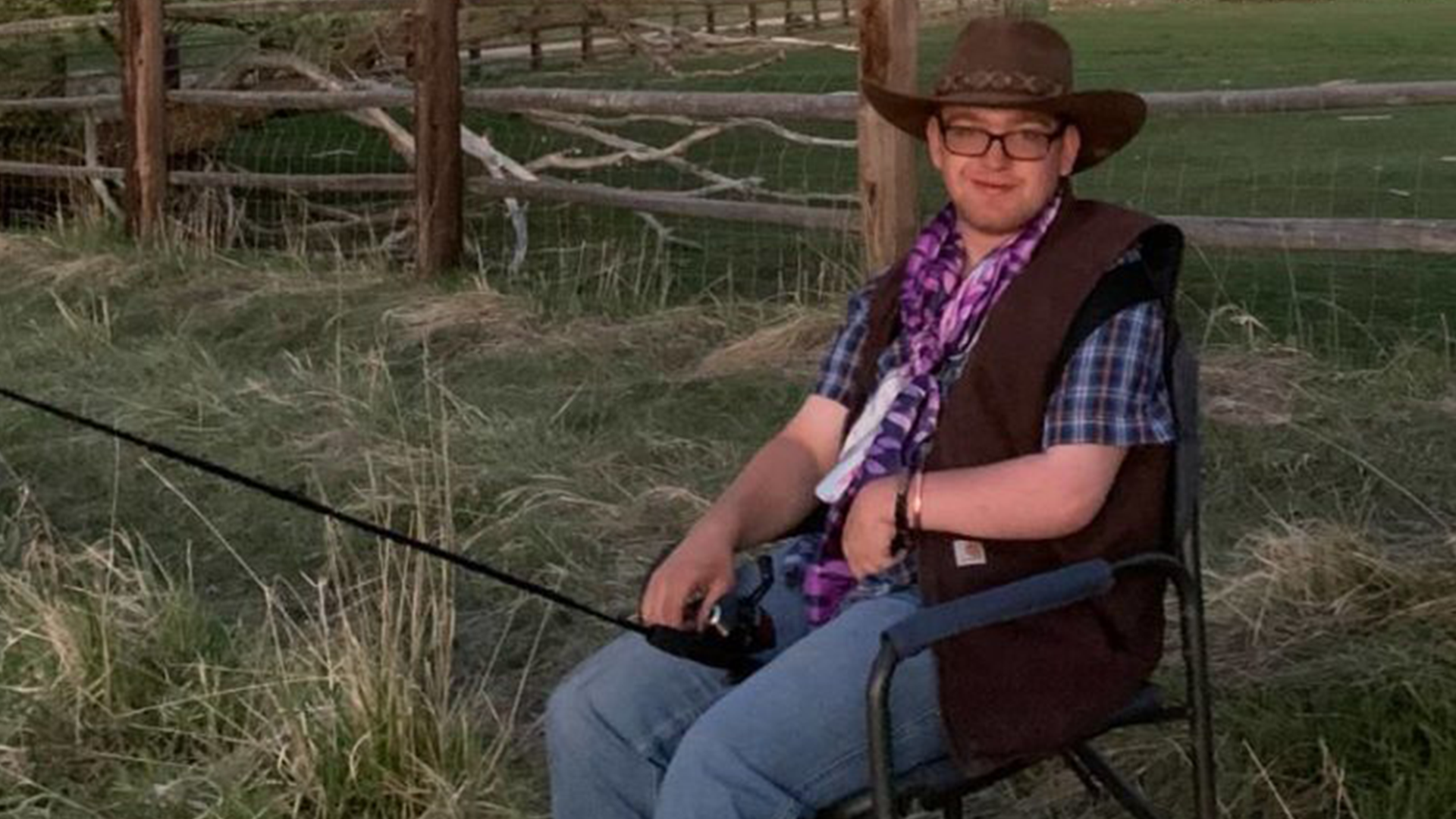 Robert Sandoz Sits wearing a cowboy hat holding a fishing pole