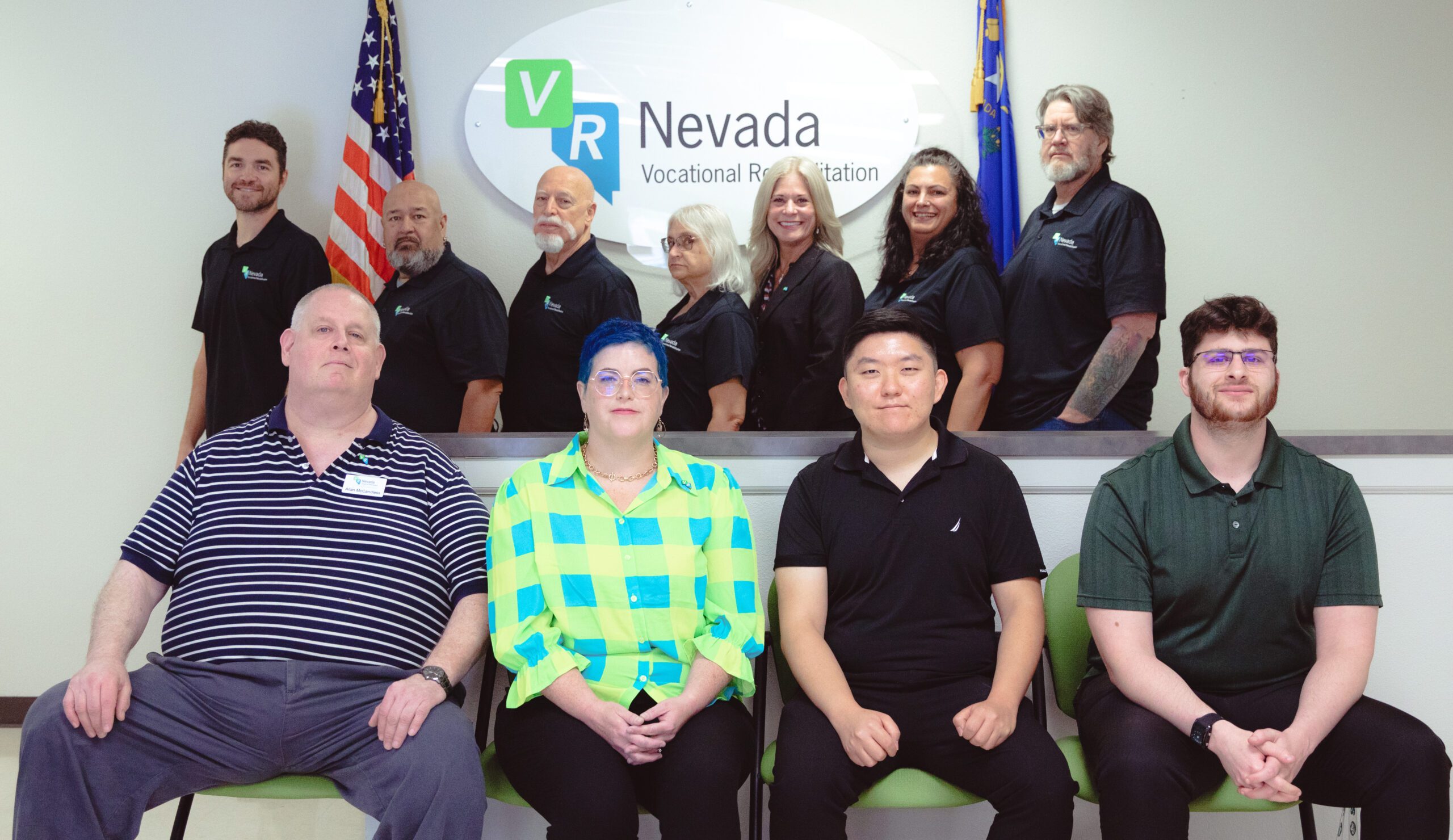 Diverse members of the VR Nevada Staff pose in the Northern Nevada lobby in front of the VR Nevada sign.