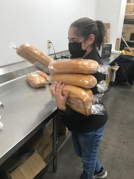 Sinai Lopez carries loaves of bread