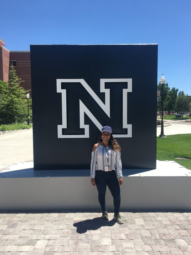 Tanya smiles in front of the UNR sign